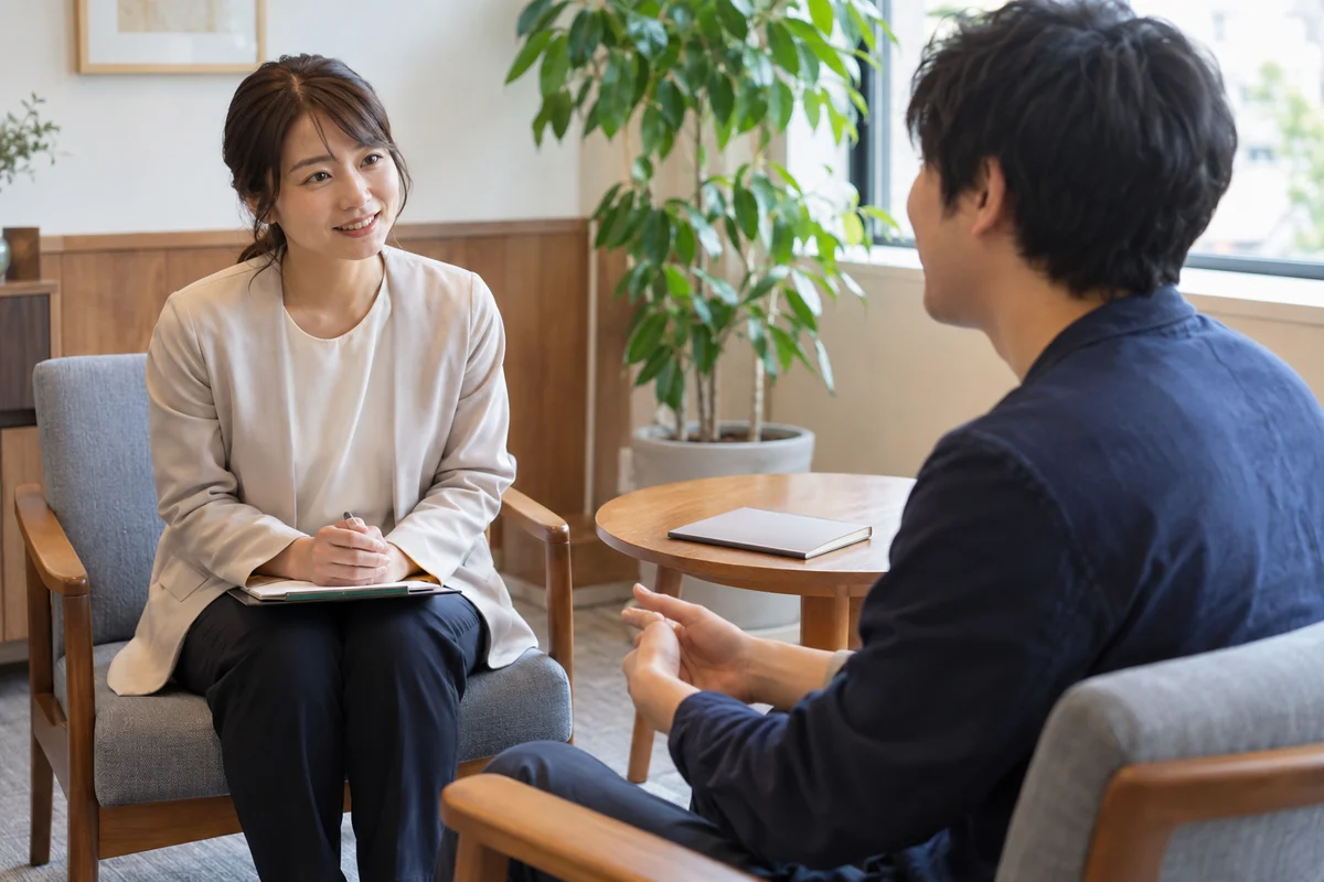 個室で成人相談者の話を聴く相談支援担当者のイメージ